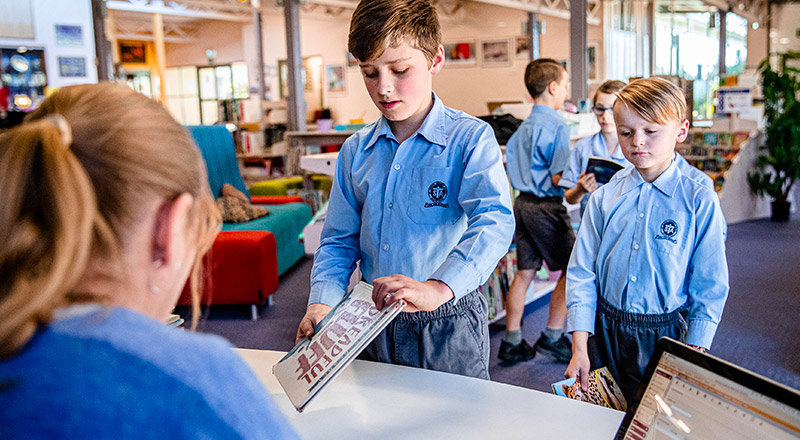 Student borrowing books from the St Thomas Aquinas Catholic Primary Springwood School Library