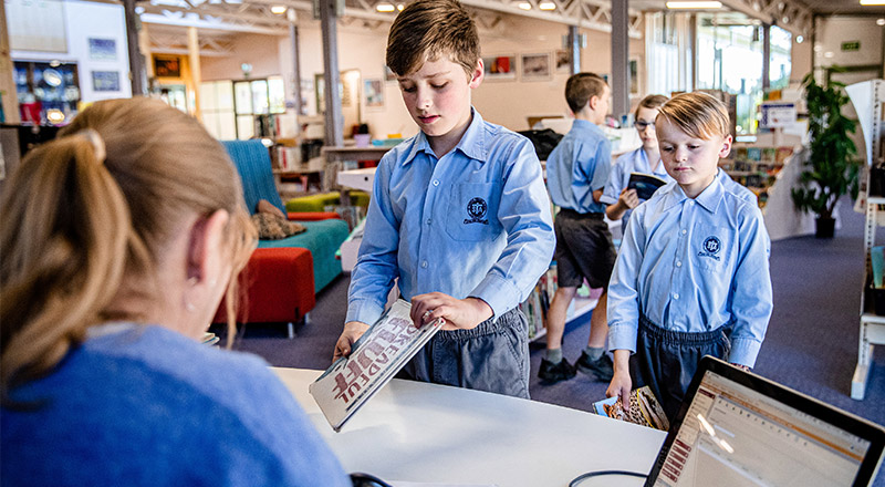 Students getting books checked out from the St Thomas Aquinas Catholic Primary Springwood school library