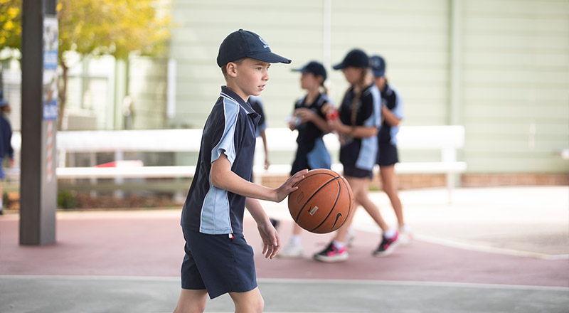 St Thomas Aquinas Catholic Primary School student playing basketball